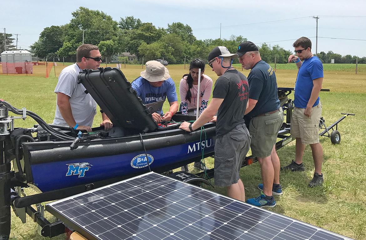 Solar boat team members make changes during Solar Splash.