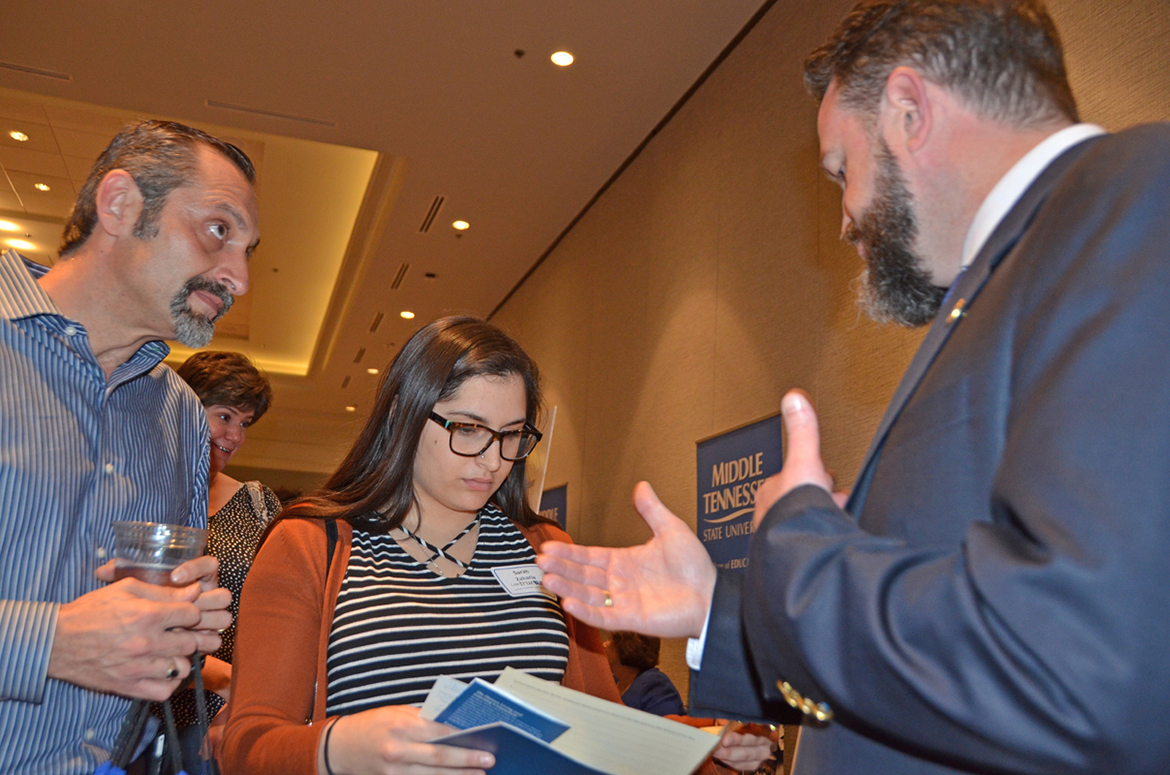 Dr. Philip Phillips, right, associate dean for the MTSU Honors College, points out information in the college’s brochures to Sarah Zakaria as her father, Radwan Zakaria, listens Oct. 26 during the university’s True Blue Tour at the Franklin Marriott Cool Springs. Zakaria is a senior at Independence High School in Spring Hill. (MTSU photo by Randy Weiler)