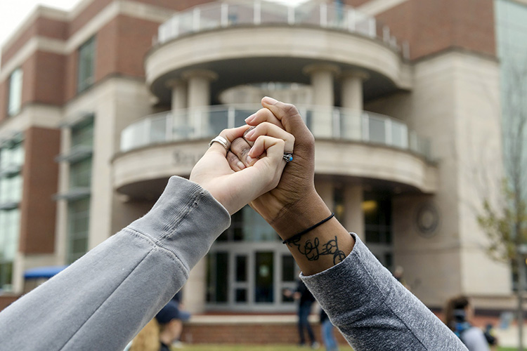 Two students link hands Monday (Nov. 6) as part of the campuswide Hands Across MTSU event to promote unity and solidarity across Blue Raider campus. (MTSU photo)