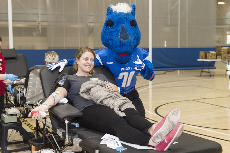 MTSU junior Mari-Lynn Wilson of McMinnville, Tenn., gets support and a big thumbs-up rom Lightning as she donates blood Monday, Nov.13, during the 2017 "Bleed Blue, Beat WKU" blood drive in the Recreation Center. The exercise science major was one of dozens helping to save lives on the drive's first day; it continues Tuesday and Wednesday, Nov. 14 and 15, from 10 a.m. to 6 p.m. each day. (MTSU photo by Andy Heidt)