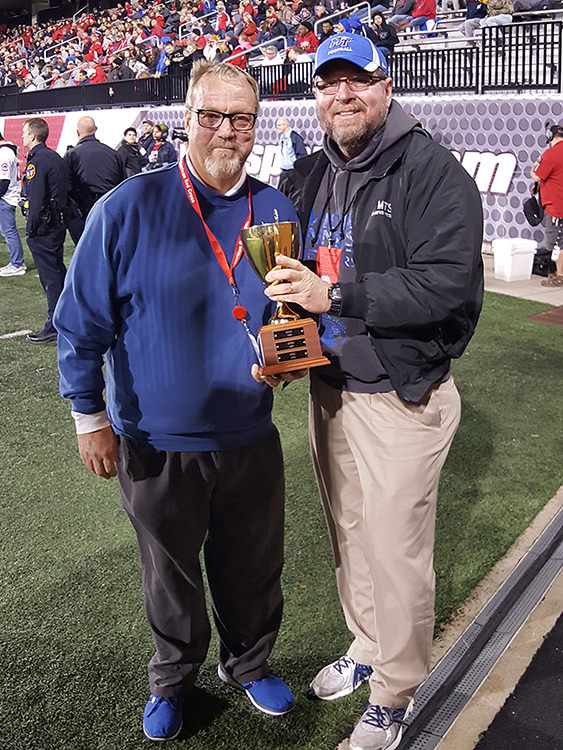 Ray Wiley, right, assistant director of MTSU Campus Recreation and a member of the university's blood drive committee, accepts the American Red Cross "MTSU vs. WKU Fall Blood Drive" challenge trophy from Gene Baker, Red Cross senior account manager for donor recruitment, during a break in the MTSU vs. WKU football game Nov. 20 in Bowling Green, Ky. MTSU community donors gave 461 pints of blood to win the friendly seven-year competition for the fifth time. (Photo submitted)