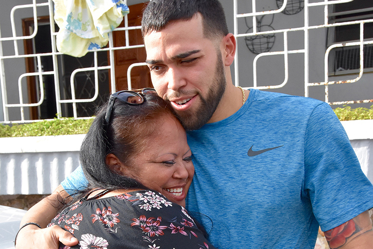 Former MTSU basketball player Raymond Cintron, right, and his mother, Luz Cortes, share a hug Wednesday, Nov. 15, in Puerto Rico after the arrival of the MTSU Raider Relief team that brought needed supplies for Cintron’s family. (MTSU photo by Andrew Oppmann)
