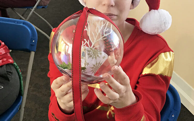 A young artist proudly displays his special teapot ornament, created during an afternoon Borderless Arts Tennessee workshop at MTSU, that is now decorating Tennessee's state Christmas tree in Washington, D.C,. The tree is on display through Jan. 1 along the “Pathway of Peace” on the Ellipse in President’s Park in Washington, surrounding the National Christmas Tree. (Photo courtesy of Borderless Arts Tennessee)