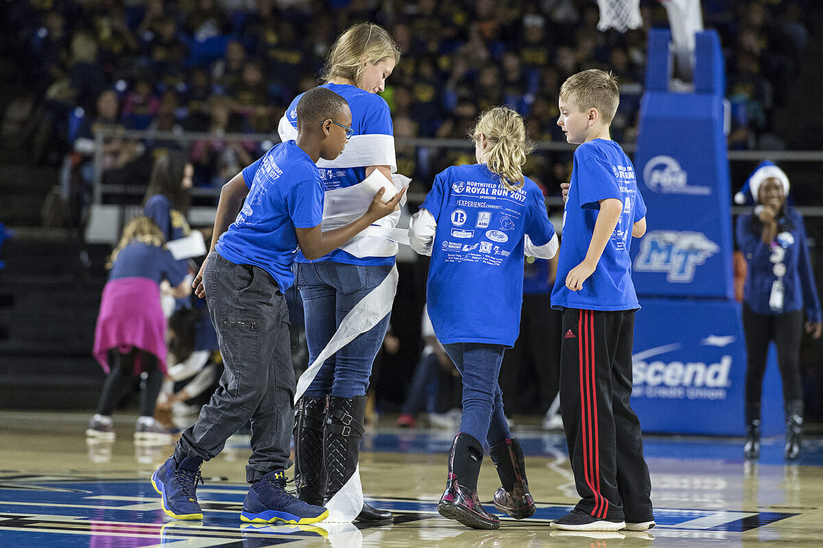 Murfreesboro City Schools students use toilet paper in a contest to turn their teachers into snowmen during the Education Day women’s basketball game Dec. 5 in MTSU's Murphy Center. (MTSU photo by Andy Heidt)