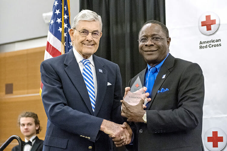Middle Tennessee State University President Sidney A. McPhee, right, is presented the 2018 Hero Award by MTSU’s John Hood at the Feb. 21 Heroes Breakfast by the American Red Cross Heart of Tennessee Chapter inside the MTSU Student Union Ballroom. Hood, director of community engagement and support, was the 2017 recipient of the award. (MTSU photo by J. Intintoli)