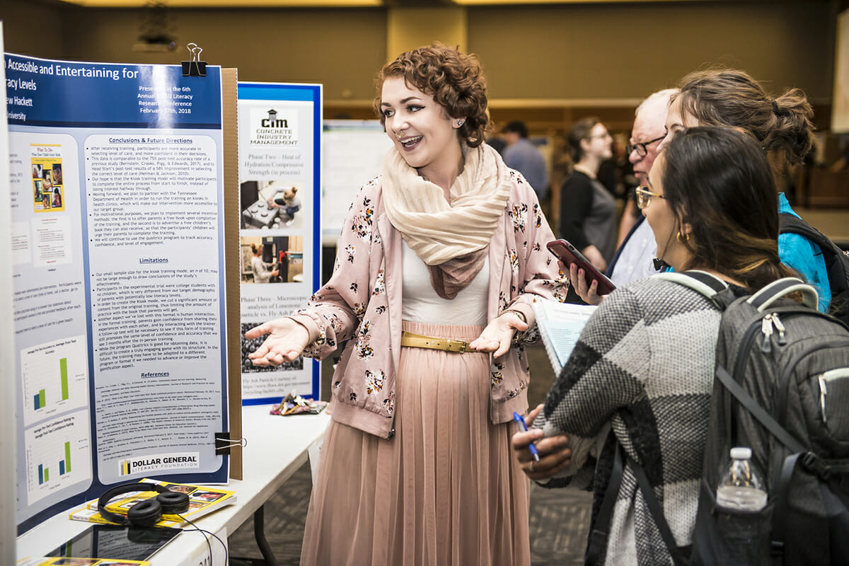 MTSU senior Maeve Bleistein, a then-psychology major from Franklin, Tenn., and 2018 MTSU graduate, discusses her poster and research with people attending the universitywide Scholars Day during the annual Scholars Week in 2018.