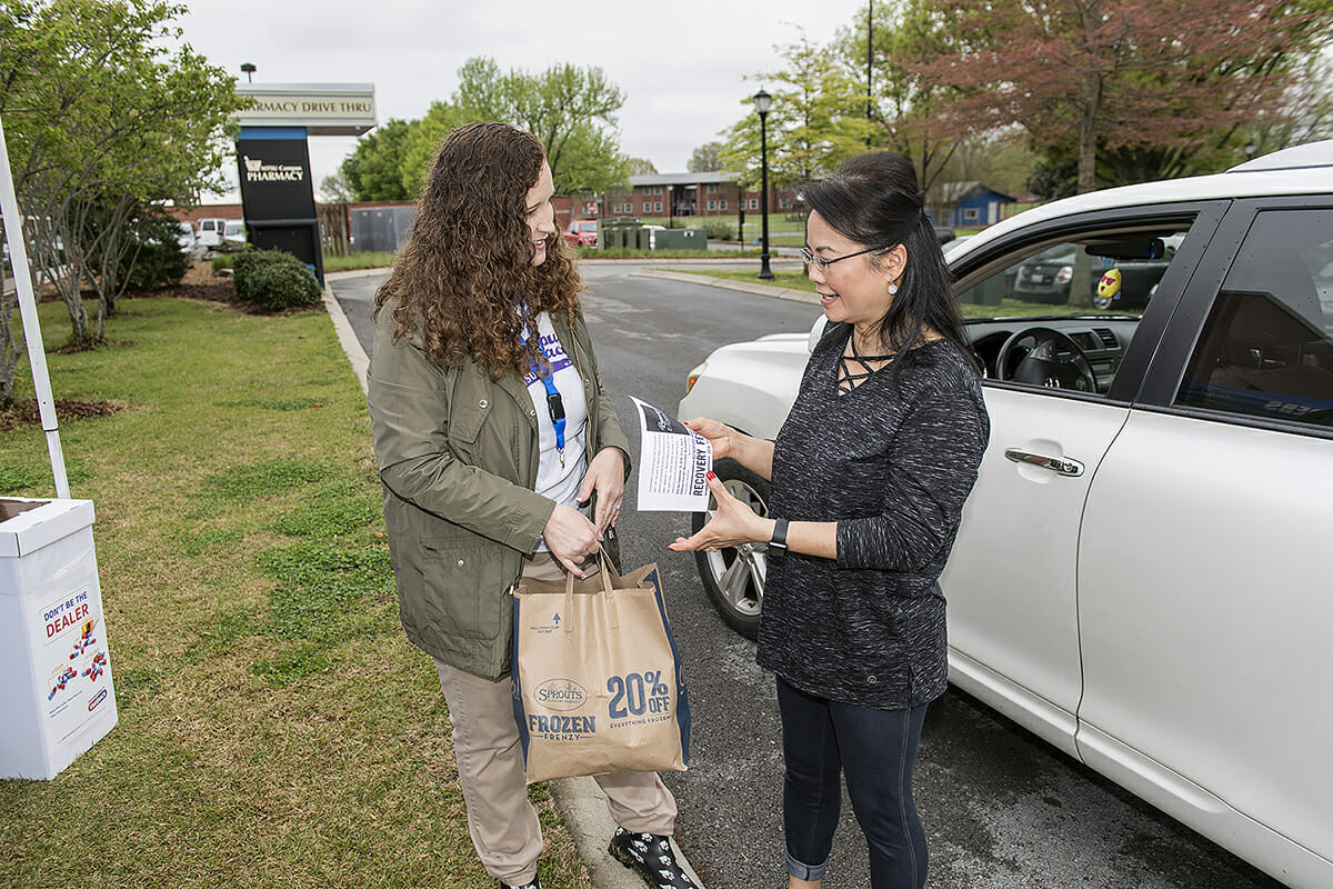 MTSU pharmacist Tabby Ragland accepts 5 pounds of unwanted drugs from Thong Bacon.