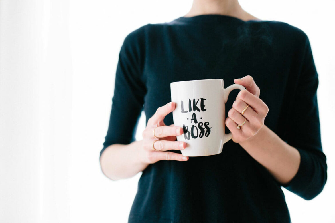 Image of woman holding a coffee cup that reads