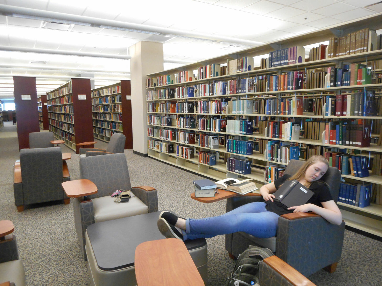 Student napping on the fourth floor of the James E. Walker Library on campus. Photo by Angele Latham.