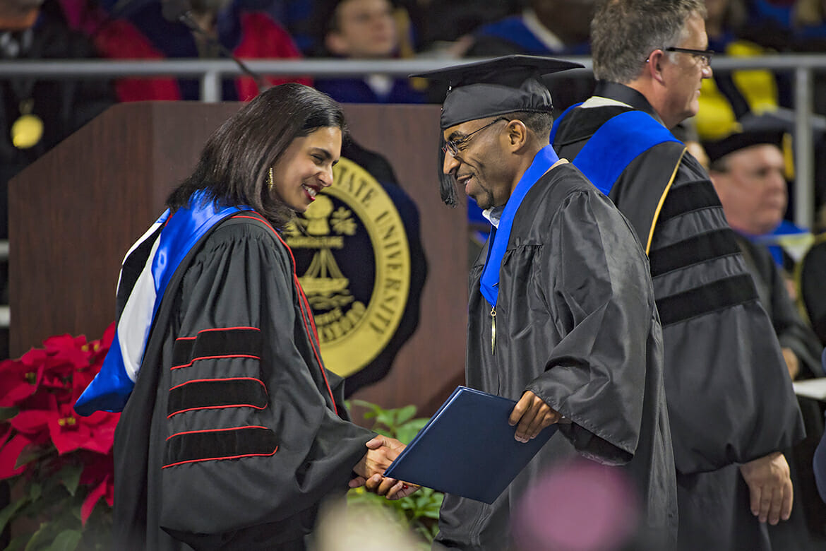 MTSU graduate Tyree Rumph receives congratulations from commencement speaker Maneet Chauhan, left, after receiving his degree in liberal studies during the December 2017 afternoon commencement ceremony inside Murphy Center. (MTSU file photo by Kimi Conro)