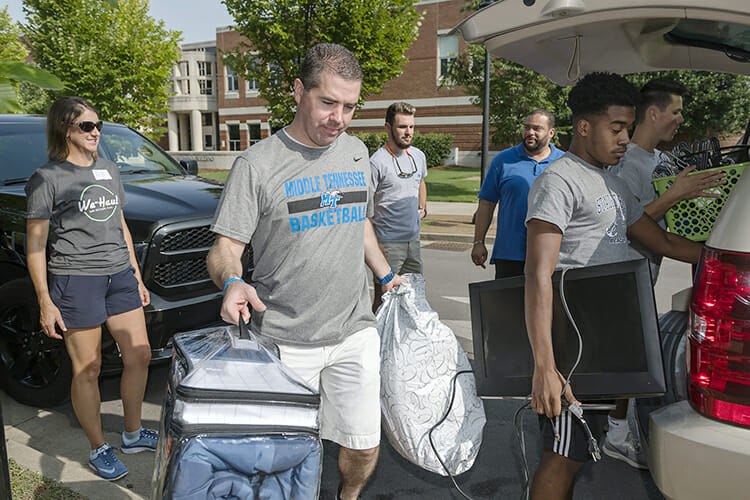 Nick McDevitt, center, MTSU head men’s basketball coach, helps unload a vehicle filled with a student's belongings Friday, Aug. 24, outside Corlew Hall during the annual We-Haul move-in event. Volunteers helped hundreds of students get settled into their dorms in preparation for the start of fall semester classes Monday, Aug. 27. (MTSU photo by J. Intintoli)
