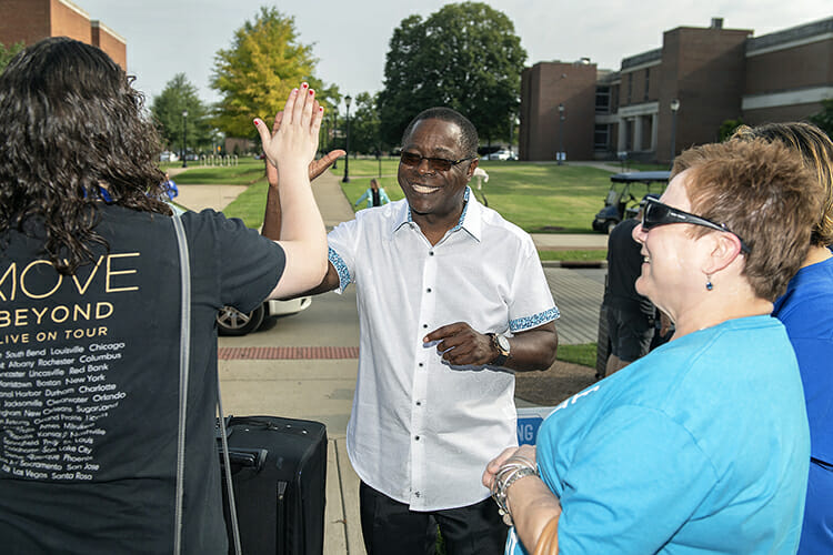 MTSU President Sidney A. McPhee, center, high-fives freshman Jessica Nasca, left, of Hendersonville, Tennesseee, while her mother, Beverly, right, watches during the annual We-Haul move-in event outside Corlew Hall on Friday, Aug. 24. Classes for fall 2018 begin Monday, Aug. 27. (MTSU photo by Andy Heidt)