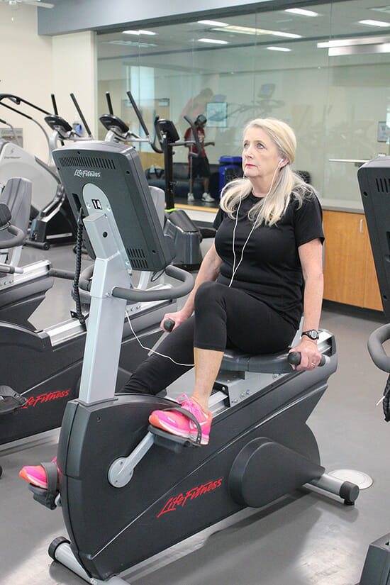 Sara Pollard, executive aide at the MTSU Campus Recreation Center, works out on one of the recumbent stationary bicycles at the Rec as part of her lunchtime fitness routine. (Photo courtesy of Campus Recreation)