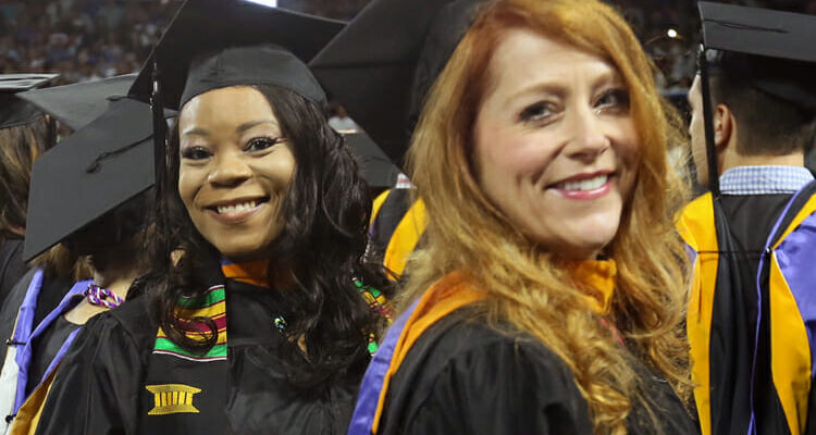 Two summer 2018 MTSU graduates smile as they stand in line during the August commencement ceremony in Murphy Center. MTSU will present 1,731 degrees at its two fall 2018 commencement ceremonies, set at 9 a.m. and 1:30 p.m. Saturday, Dec. 15. (MTSU file photo by GradImages.com)