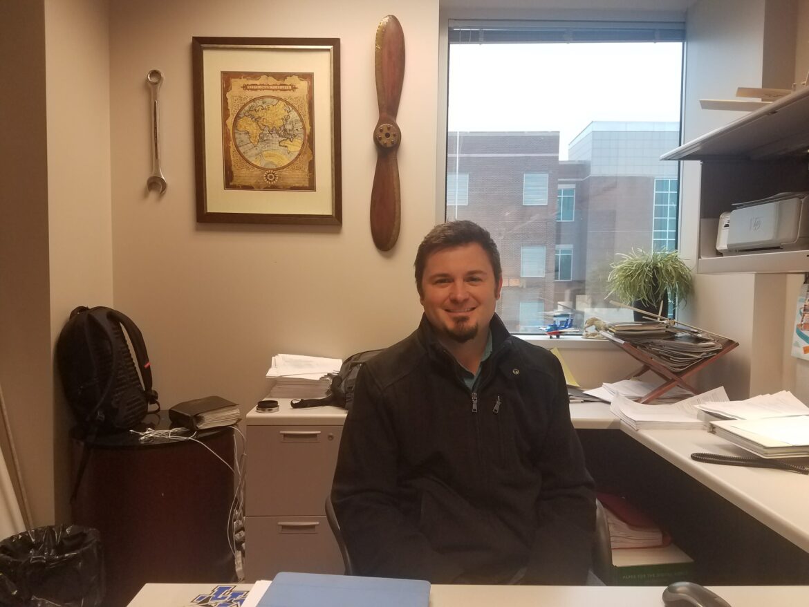 Tyler Babb, Aerospace professor, sitting in his office.