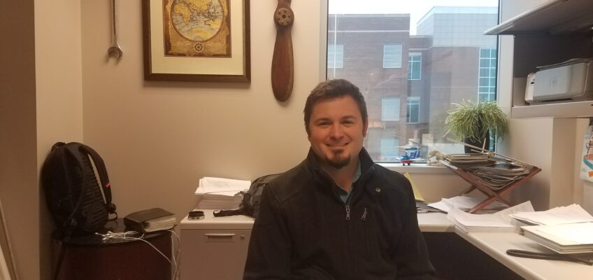 Tyler Babb, Aerospace professor, sitting in his office.
