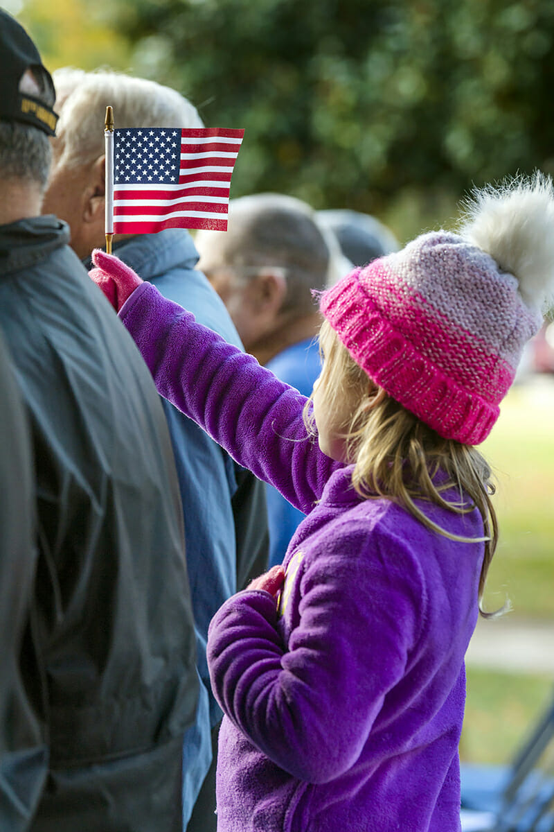 Raina Grace Kelton, 5, of Madison, Ala., waves a small U.S. flag.