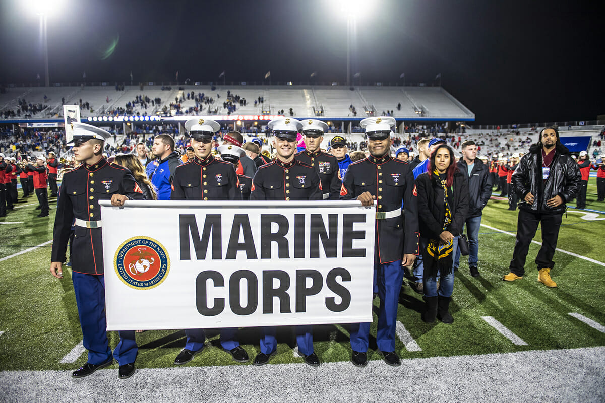 Marines walk across the field at halftime.