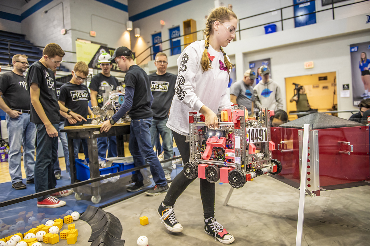 Carrying her team's robot