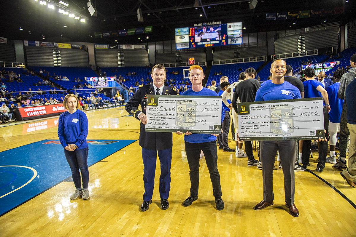 U.S. Army Lt. Col. Carrick McCarthy, center left, chair of MTSU's Department of Military Science, presents scholarships to Caleb Rowland, center right, and Ladarius Fitzgerald during Military Appreciation Night Jan. 30 in Murphy Center. Looking on at left is fellow new MTSU cadet Jordan Plumb. (MTSU photo by Eric Sutton)