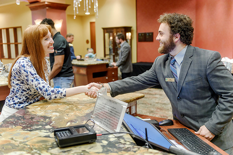 MTSU student Will Mitchell, right, greets a colleague inside Embassy Suites Murfreesboro in this promotional photo for the university’s new Tourism and Hospitality Management Bachelor of Science Degree Program, the only college degree track of its kind in Middle Tennessee. Mitchell also works at the hotel. MTSU’s program launches in fall 2019. (MTSU photo by Eric Sutton)