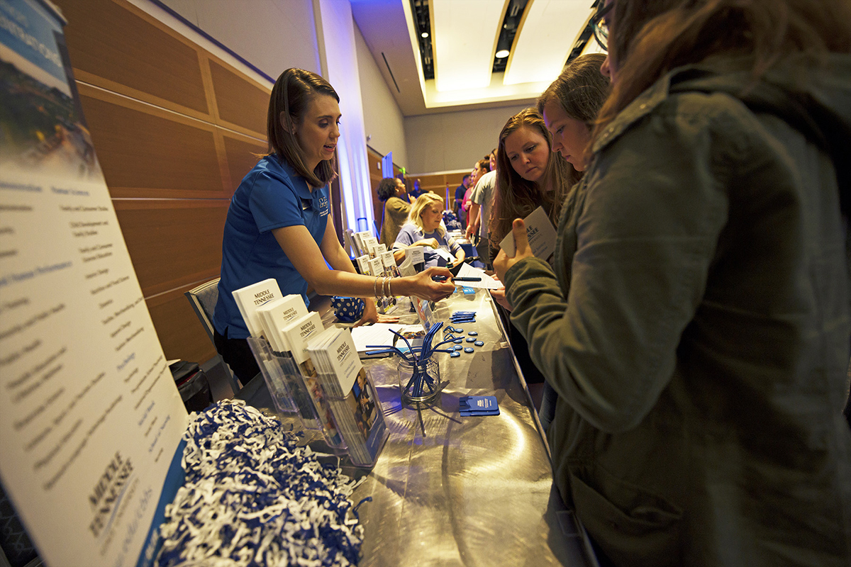 Chloe Calhoun, left, adviser in the College of Behavioral and Health Sciences, shares information about her college’s offerings during the recent True Blue Tour event in the Student Union Ballroom. MTSU staff and administrators answer questions prospective students have about the university and its academic programs and more. (MTSU photo by Cat Murphy)