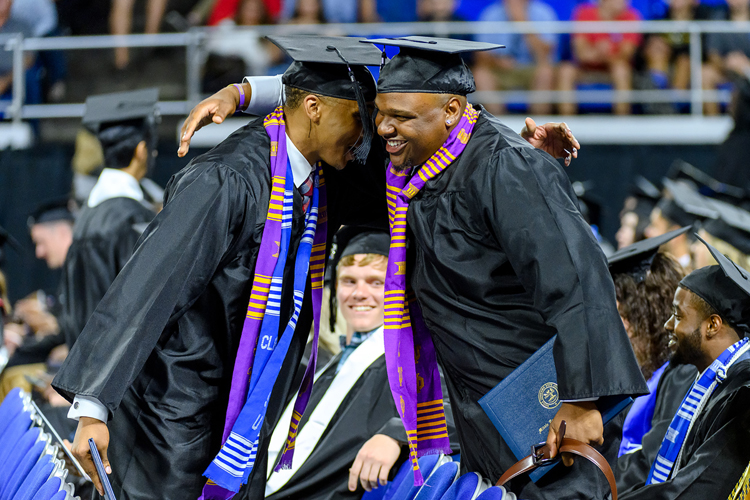Two members of MTSU’s Class of 2019 congratulate each other on reaching their goals Saturday, Aug. 10, during the university’s summer 2019 commencement ceremony in Murphy Center. MTSU awarded 817 degrees during the event to 603 undergrads and 214 graduate students. (MTSU photo by J. Intintoli)