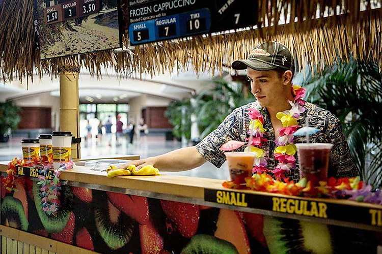MTSU junior Nathan Fink of Horicon, Wisconsin, cleans the counter between customers at his “Maui Wowi” smoothie franchise. Fink, a music business major and an entrepreneur since childhood, operates two businesses to pay for his college education and graduate debt-free. (Photo courtesy of Nathan Fink)