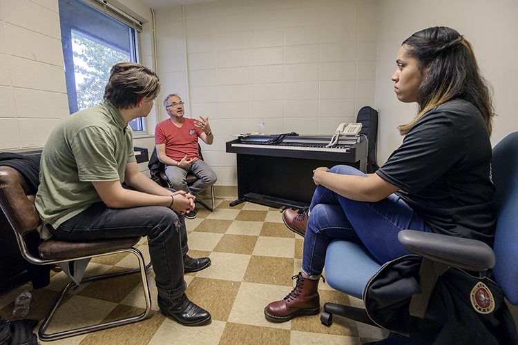 Grammy-winning songwriter Marcus Hummon, center, makes a suggestion to MTSU senior songwriting major Jody Chamberlain of Tucker, Georgia, left, and Teresa Carter, a U.S. Marine veteran and MTSU pre-med major, during their writing session at Operation Song's fourth annual “Songs and Stripes” event at MTSU Friday, Oct. 25. The event teams trios of military veterans, student and professional songwriters to create healing music for the veterans and training for the students. (MTSU photo by Andy Heidt)