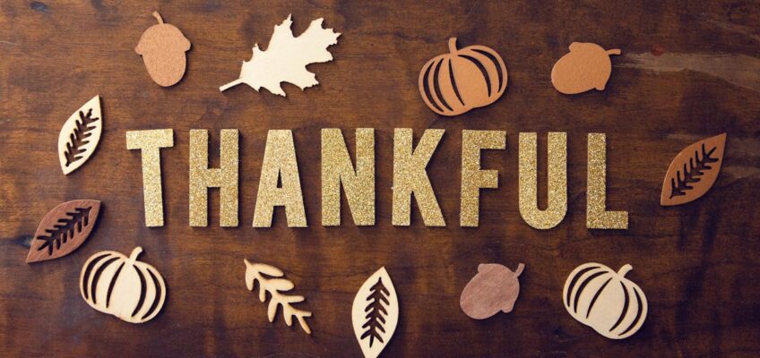 Tabletop photo of block letters spelling Thankful surrounded by Thanksgiving themed cutouts. Photo by Pro Church Media on Unsplash.