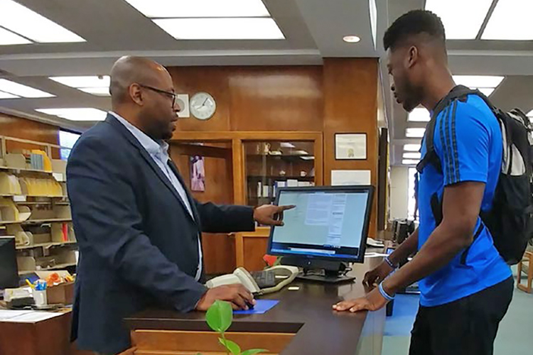 In this undated photo, MTSU alumnus Brandon Owens assists a student in his role as assistant librarian for technical services at the John Hope and Aurelia E. Franklin Library at Fisk University in Nashville, Tennessee. Owens is a graduate of MTSU’s Master of Library Science online program. (Photo courtesy of Clarke Bagsby/Fisk University)