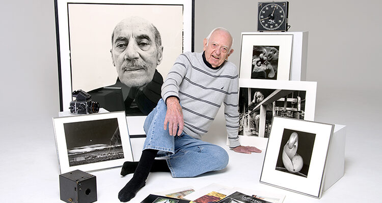 MTSU Professor Emeritus Harold L. Baldwin poses with prints by internationally recognized photographic masters from the university's million-dollar-plus collection, along with copies of the MTSU photography magazine Lightyear, vintage cameras and a darkroom timer in this 2012 file photo. Baldwin, 93, founder of both MTSU's photography program and the renowned campus photo gallery that bears his name, died March 19. (MTSU file photo by J. Intintoli)