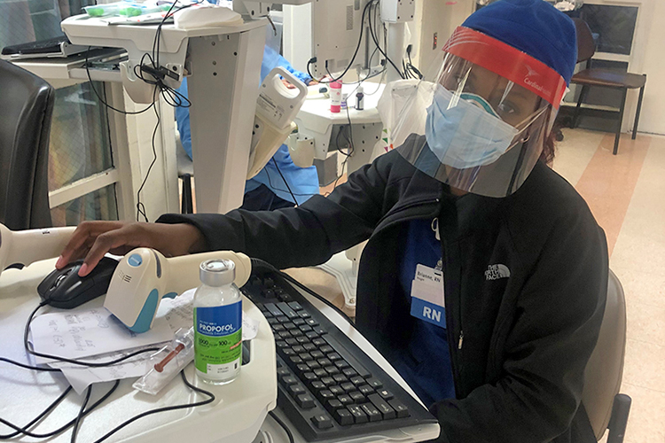 MTSU alumna Brianne Knight, dressed in personal protective equipment, enters data into a computer at a New York City hospital where she is working as a critical care nurse. (Photo submitted)