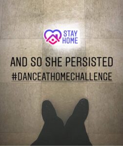Cassidy Johnson takes a picture of her feet in the dorm hallway, with text superimposed over the image saying "And so she persisted, #dance at home challenge"
