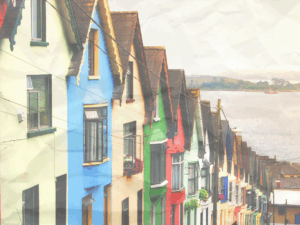 A street in Cobh, Ireland, lined with colorful houses that slope into the sea. 