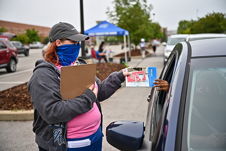 Jamie Chumbley of MTSU's Parking and Transportation Services hands a new parking permit and brochure to a student at a special drive-through checkpoint Wednesday, Aug. 19. Students are moving in to MTSU dorms through Aug. 23 by individual appointment, instead of the customary two-day open event, to help maintain health safety conditions, and Parking Services joined the move-in checkpoint line to make the process more efficient. Fall semester classes begin Monday, Aug. 24. (MTSU photo by J. Intintoli)