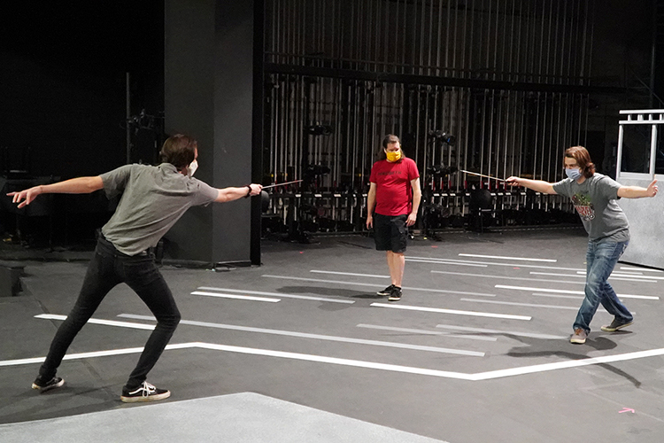 MTSU Department of Theatre and Dance lecturer David Wilkerson, center, watches closely as junior Geo Sekeres of Goodlettsville, Tenn., left, who portrays Mercutio, duels with senior Luke McGuire of College Grove, Tenn., who portrays Tybalt, during rehearsals for the university's Oct. 1-4 production of William Shakespeare's "Romeo and Juliet." The production will air live from Tucker Theatre at MTSU.edu/live, the True Blue TV channel and the MTSU and MTSU Theatre Facebook Live sites. A few free in-person tickets are also available for students. (MTSU Department of Theatre and Dance photo)