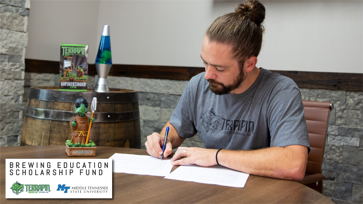 Terrapin Beer Co. President Dustin Watts signs the agreements establishing a $10,000 scholarship to underrepresented undergraduate students wanting to pursue a degree in fermentation science at MTSU. “We want to grow diversity within Terrapin and within the brewing industry as a whole,” he said. (Photo submitted by Terrapin Beer Co.)