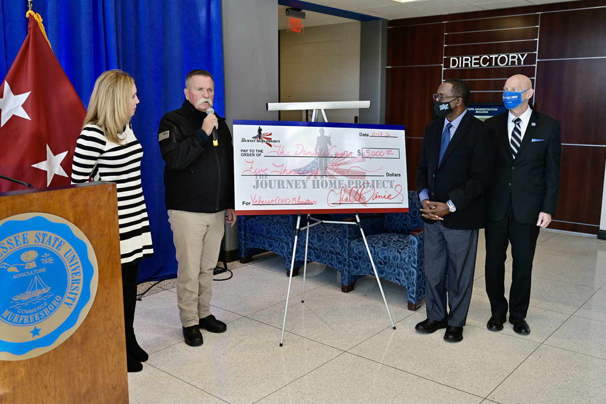 David Corlew, second from left, representing The Journey Home Project, presents a check for $5,000 to the Charlie and Hazel Daniels Veterans and Military Family Center Wednesday, Nov. 18, as part of the Graduating Veterans Stole Ceremony, held virtually for the honorees because of COVID-19 safety protocols, in the Cope Administration Building lobby. Looking on are Daniels Center Director Hilary Miller, left, MTSU President Sidney A. McPhee and Keith M. Huber, senior adviser for veterans and leadership initiatives and a retired U.S. Army lieutenant general. (MTSU photo by Andy Heidt)