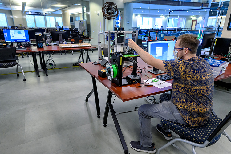 Keri LaPrairie, a student worker at Makerspace, operates equipment in an environment redesigned and adapted for COVID-19 social distancing protocols. (MTSU Photo by J. Intintoli)