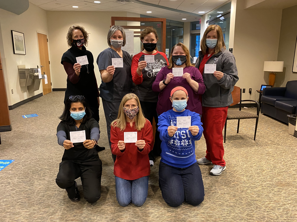 A group of MTSU Health Services and Pharmacy staff members hold their reminder cards after receiving the first of two COVID-19 vaccines Wednesday, Dec. 23, at the Siegel High School Gym in Murfreesboro. They were among about 15 MTSU staff members given the Moderna vaccine. The group includes, front row from left, Dr. Aruna Shah, April Magnuson and Amanda Scales, and back row from left, Heather Ashby, Tabby Ragland, Shannon Shaffer and Susan McConnell. (MTSU photo by Jason Schrader)