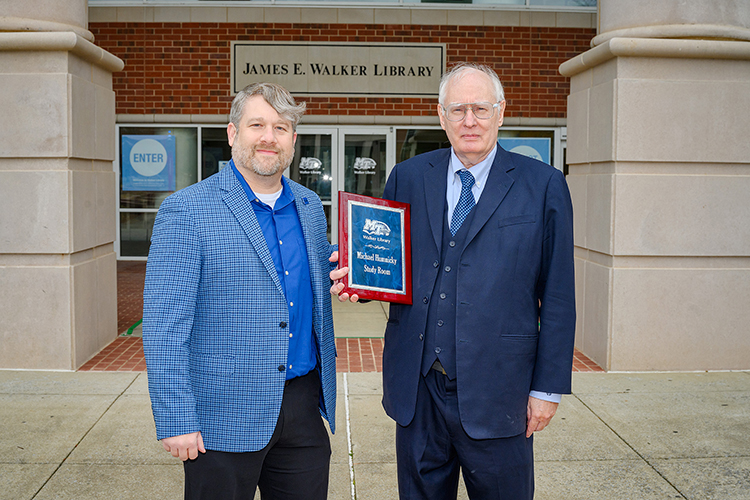Paul Wydra, left, MTSU's director of development initiatives, poses with long-time donor Michael Humnicky and the plaque designating the study room named in his honor at the James E. Walker Library. (MTSU Photo by J. Intintoli)