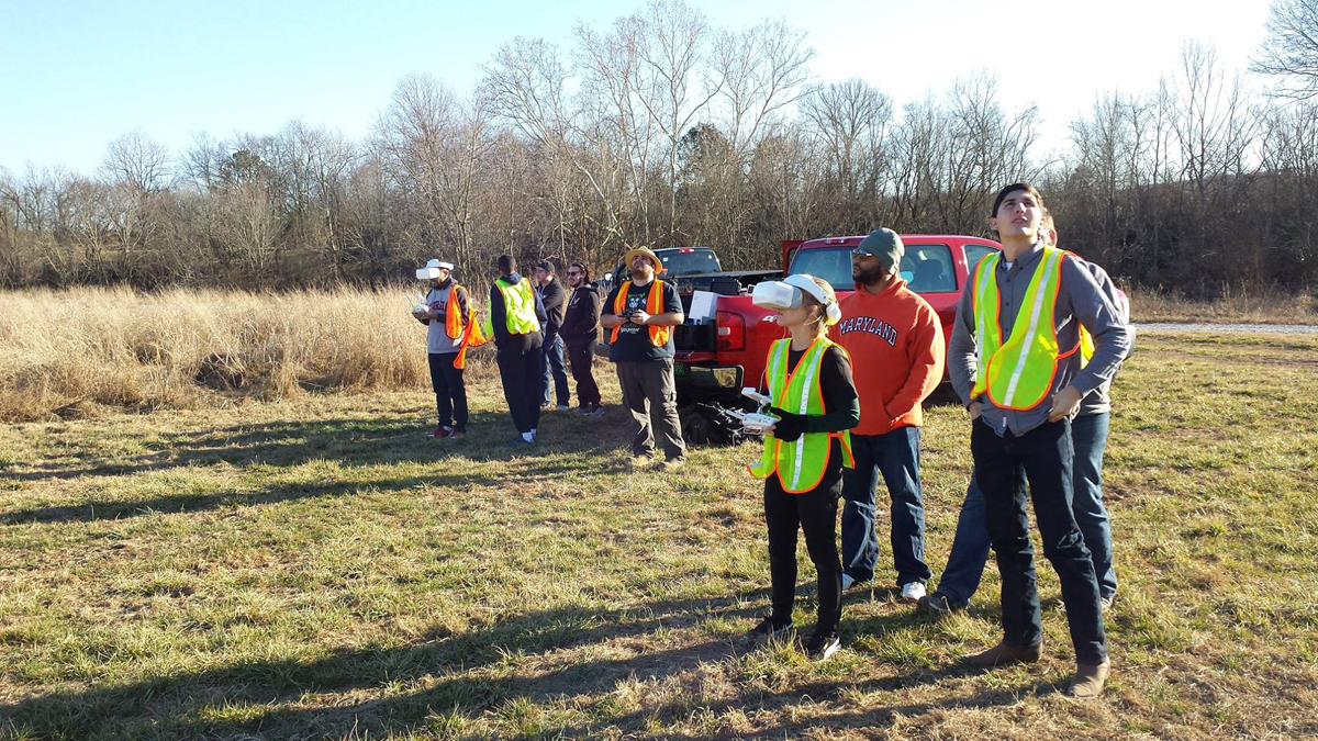 In a photo taken at the MTSU Farm in Lascassas, Tenn., before the COVID-19 pandemic forced people to wear masks and social distance, Cat Bradley, foreground, and Unmanned Aircraft Systems Operations classmates fly drones. (MTSU photo submitted by Kevin Corns)