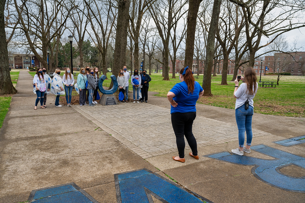 Miura Rempis, left foreground, and Ashley Conser take a recent in-person MTSU daily campus tour group to the Blue Horseshoe in Walnut Grove near Peck Hall for a photo opportunity. The tours, which are led by Blue Elite students, last approximately one hour. (MTSU photo by Andy Heidt)