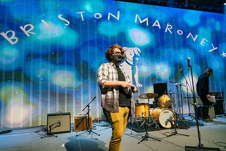 Gabriel Stanley, a senior audio production major from Speedwell, Tennessee, checks a microphone on stage during setup Wednesday, March 24, for the Briston Maroney concert in MTSU's Student Union ballroom. Stanley was one of nearly 50 students from two different colleges — and three departments — who collaborated to present MTSU's first in-person, large-scale "Signature Event" since 2019. Department of Media Arts students designed and built the 40-foot-by-18-foot video wall on stage behind Stanley, whose major is in the Department of Recording Industry. (MTSU photo by Andy Heidt)