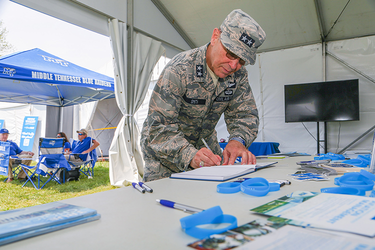Maj. Gen. Mark Smith, Civil Air Patrol’s national commander and chief executive officer, signs the guest book Monday, July 26, at Middle Tennessee State University’s Aerospace Department booth on the grounds of the EAA AirVenture 2021 happening all week in Oshkosh, Wisc. (U.S. Air Force Auxiliary photo by Lt. Col. Robert Bowden)
