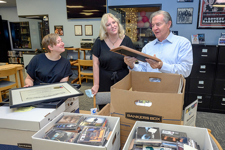 Rachel Morris, archivist; Beverly Keel, Dean of the College of Media and Entertainment; and Jim Free, MTSU alumnus and member of the Country Music Association board, examine event programs, ticket stubs, backstage passes, and other entertainment artifacts Free donated Monday, Aug. 16, to the Center for Popular Music in the Bragg Building at MTSU. (MTSU Photo by J. Intintoli)