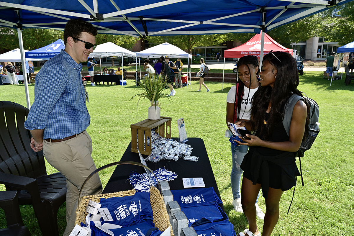 Murfreesboro Medical Clinic marketing specialist Dalton Tracy, left, provides information about the health care facility to MTSU students Ty Miles, center, of Murfreesboro, and Eve Hoffman of Liberia, Africa, during the first day of the two-day MTSU New Student and Family Programs Meet Murfreesboro event Tuesday, Aug. 24, in the Student Union Commons. Miles is a senior graphic design major while Hoffman is a junior fashion merchandising major. (MTSU photo by Andy Heidt)