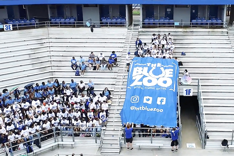 A group of MTSU students unfurl the giant Blue Zoo banner for the first time in two years on Thursday, Aug. 19, inside Floyd Stadium in preparation for the upcoming football season. (MTSU screen capture)