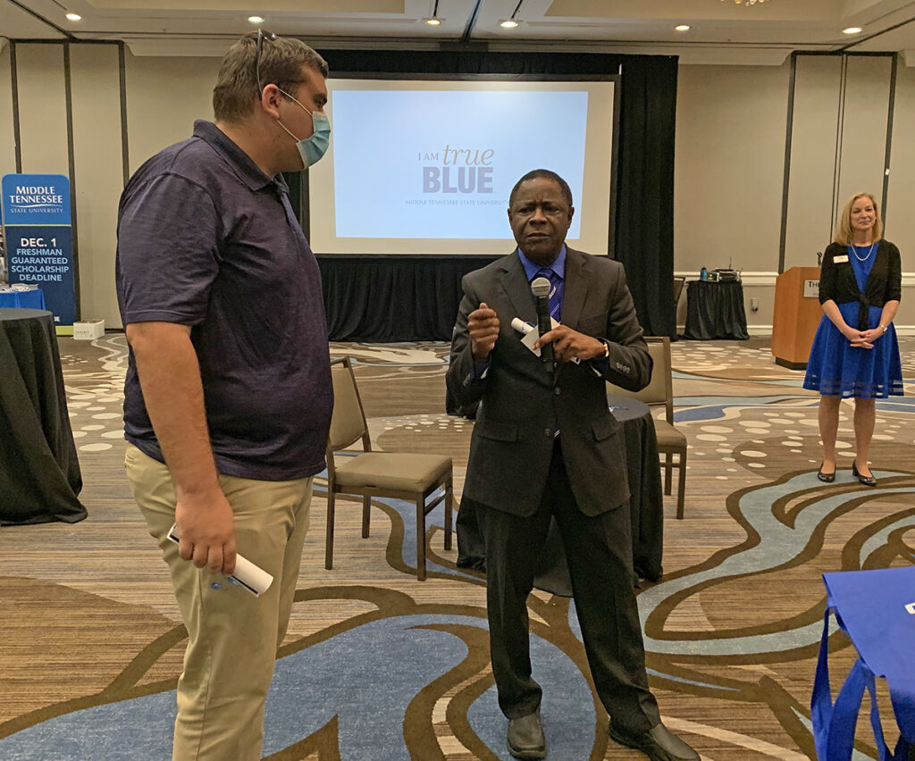 MTSU President Sidney A. McPhee, right, awards Zach Zanowski of Summerville, S.C., a $1,000 scholarship and gift certificate to the MTSU Phillips Bookstore after learning of the student’s plans to transfer into the MTSU mechatronics engineering program in January. Zanowski and his father, Steve, drove five hours one way to attend the True Blue Tour event at The Westin Atlanta Perimeter North on Oct. 19. (MTSU photo by Randy Weiler)